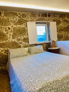 - une chambre avec un lit et un mur en pierre dans l'établissement Quinta Lourenca - Vila do Conde, à Vilar