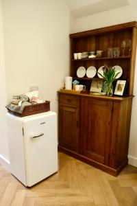 a kitchen with a white refrigerator and a wooden cabinet at Barton Hollow in Barton on Sea