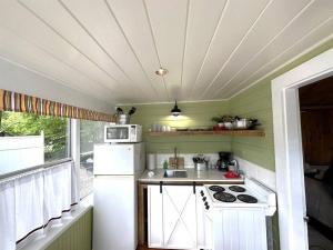 cocina pequeña con nevera blanca y fogones en Cottage 11 - 1 Bed / 1 Bath w/ Private Courtyard, en Wolfeboro