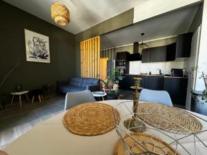 eine Küche und ein Wohnzimmer mit einem Tisch und Stühlen in der Unterkunft Les Copains d'Abord in Nîmes