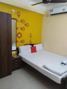 a room with two beds and a yellow wall at The Coco Inn Near South City Mall by Urban in Kolkata