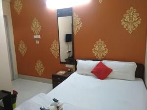 a bedroom with a bed with a red pillow and a mirror at The Coco Inn Near South City Mall by Urban in Kolkata