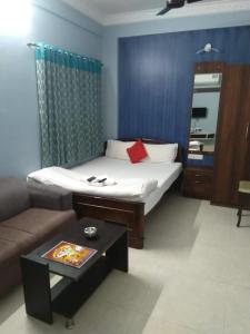 a living room with a bed and a coffee table at The Coco Inn Near South City Mall by Urban in Kolkata