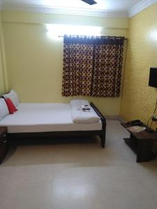 a small room with a bed and a window at The Coco Inn Near South City Mall by Urban in Kolkata