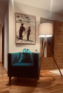 sala de estar con sofá azul y lámpara en Biancas Luxury Apartment close Ischgl Spa & Pool, en Kappl