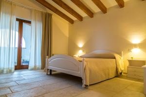1 dormitorio con 1 cama blanca en una habitación en Masseria Martellotta, en Palagianello