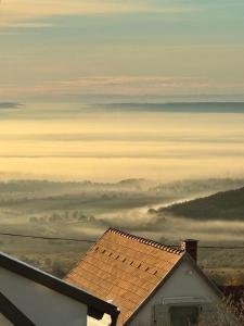 vistas a un campo de niebla con una casa en Vulkán Nyúlontúl, en Mencshely
