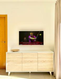 TV en una pared blanca con tocador de madera en Hoteltype Penthouse 2 Beds, Parking, WIFI & pool Stunning Views, en Denia