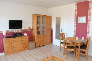 a living room with a dining room table and a television at Fewo 91 WHG A 14 in Burhave in Burhave