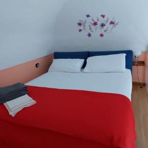 a bed with a red and white blanket on it at La solution 2023 in Vico Equense