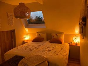 1 dormitorio con 1 cama con 2 lámparas y una ventana en Bed & Breakfast - appartement d'Ambacht, en Borger
