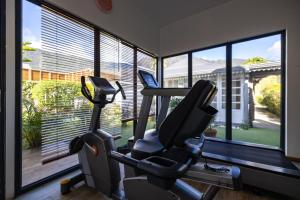 a gym with two exercise bikes in a room with windows at Le Vieux Cep in Cilaos