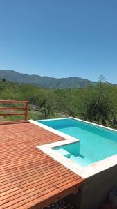 a swimming pool with a wooden deck and a swimming poolitures at Cañada Al Lago in Villa Parque Siquiman