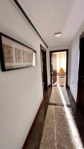 un pasillo con una pared blanca y una alfombra en YELKEN PANSİYON Sinop, en Sinope