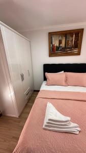 YELKEN PANSİYON Sinop في سينوب: غرفة نوم بسريرين مع ملاءات وردية وخزانة