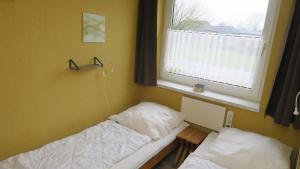 a small room with a bed and a window at Fewo 91 WHG A 14 in Burhave in Burhave