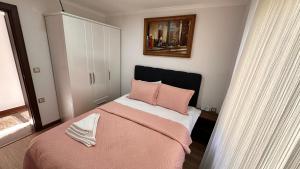 a bedroom with a pink bed with pink pillows at YELKEN PANSİYON Sinop in Sinop