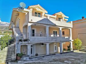 a large house with a staircase in front of it at Apartmani Kenova 4 in Herceg-Novi