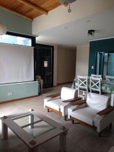 una sala de estar con 2 sofás y una pantalla de proyección en Concordia Casa barrio residencial en Concordia