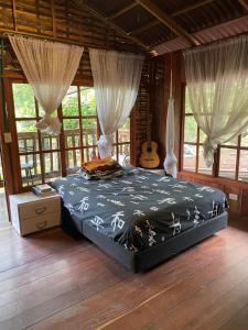 a bedroom with a bed in a room with a guitar at PALOMINO- HOSTEL BALNEARIO RIO ANCHO in Palomino