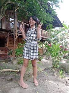 a woman is standing in front of a house at PALOMINO- HOSTEL BALNEARIO RIO ANCHO in Palomino