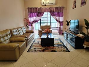 a living room with a couch and a tv at Ber-Santai at Marina Court in Kota Kinabalu