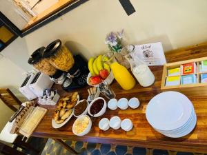 einen Tisch mit Teller mit Lebensmitteln und Obst in der Unterkunft Posada Boutique Le Vrero in Colonia del Sacramento