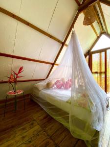 a bed with a mosquito net in a room at Restaurante, Hostal y Spa Mama Neyumun in El Zaino