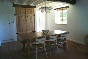 a dining room table with four chairs and a chandelier at Gîte de Magneux - Spa/Jacuzzi in Amions