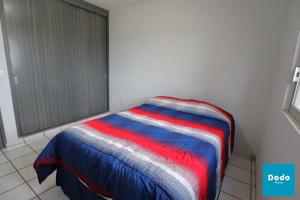 Cama en habitación con manta colorida en Condominios Plaza San Ignacio, en Mazatlán