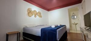 een slaapkamer met een bed met een blauwe deken bij Pousada Santiago Morumbi in Sao Paulo