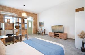 Un dormitorio con una cama, un televisor y una mesa. en Chora Aegina's Apartments, en Aegina Town