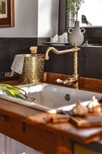 a bathroom sink with a gold faucet at Cheerful Cottage at Balatonfelvidek Dörgicse in Mencshely