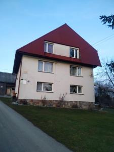 una gran casa blanca con techo rojo en Na Dziole, en Lipnica Wielka
