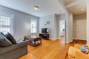 a living room with a couch and a tv at NEW! Boston Condo Near MBTA, 3Mi to Fenway! (U1) in Boston