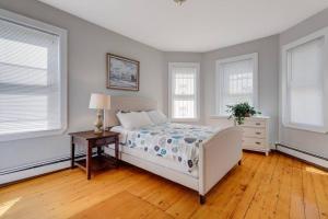 a bedroom with a bed and a table and windows at NEW! Boston Condo Near MBTA, 3Mi to Fenway! (U1) in Boston