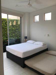 1 dormitorio con cama y ventana grande en Hermosa Casa de Descanso en Peñalisa en Ricaurte