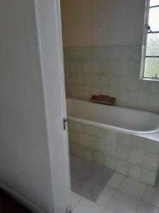 a bathroom with a white tub and a white tile floor at UNDERBERG INN in Underberg +14 photos