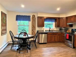 a kitchen with a table and chairs in it at Melvin Village - 5 Bed/3 Bath - Lake Winnipesaukee in Tuftonboro