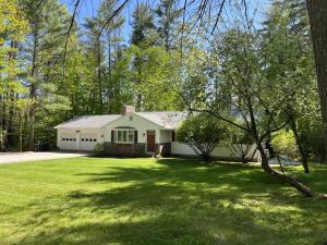 a white house in a yard with a tree at Melvin Village - 5 Bed/3 Bath - Lake Winnipesaukee in Tuftonboro