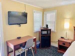 a room with a desk and a tv on the wall at Elk Rapids Lakeshore Inn in Elk Rapids