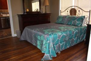 a bedroom with a bed with a green comforter at 3BR, 2BA Hidden Gem in Midtown/Evergreen district in Memphis