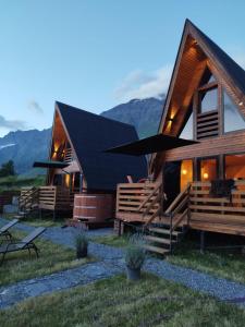 a log cabin with mountains in the background at Kazbegi Spa Resort Cottages in Kazbegi