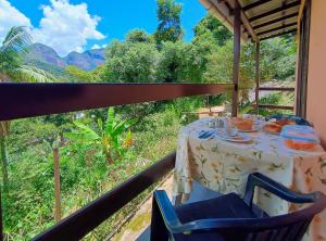 uma mesa e cadeiras com vista para as montanhas em Casa Fofa! No Coração de Araras! em Araras, Petrópolis