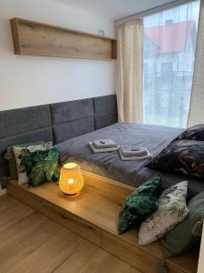 uma cama com uma plataforma de madeira com um candeeiro em Domek Roztocze em AdamÃ³w