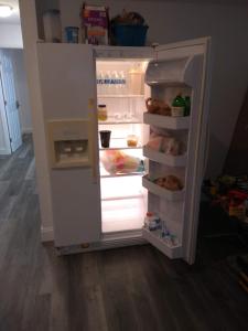 an open refrigerator with its door open and food inside at Lenny's Cooperative Hostel in Clearwater