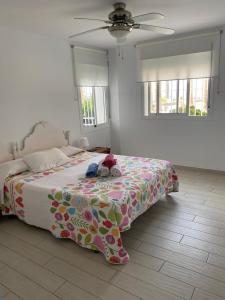 um quarto com uma cama com um bicho de peluche em Apartamento lujoso en primera linea de playa em Castell de Ferro