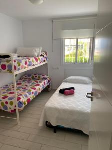 a bedroom with two bunk beds and a window at Apartamento lujoso en primera linea de playa in Castell de Ferro