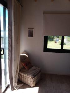 sala de estar con sofá y ventana en Hospedaje Sierra del Tigre II en Tandil