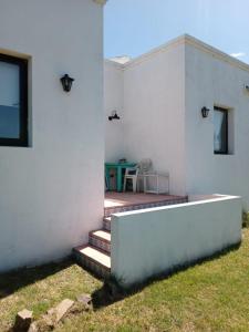 Casa blanca con una mesa en el patio en Hospedaje Sierra del Tigre II en Tandil